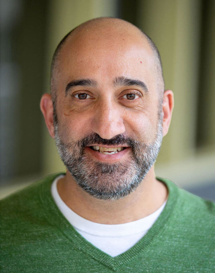 Tom Ruscica wearing a green v-neck sweater