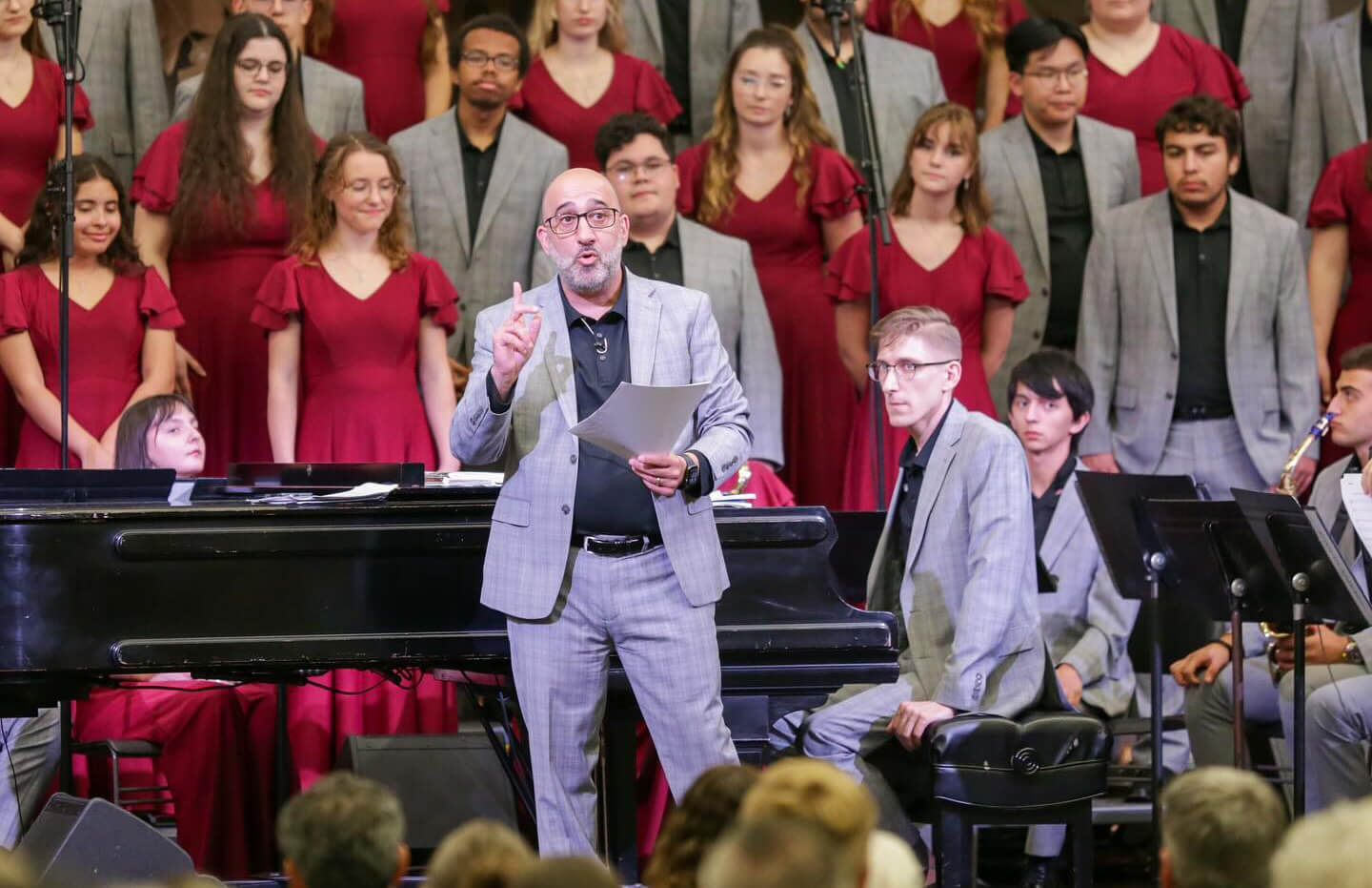 Tom Ruscica speaking to the audience at a concert